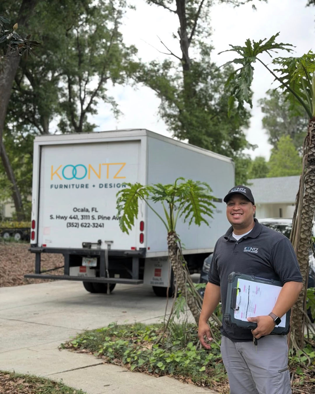 Koontz delivery truck with staff member holding delivery paperwork
